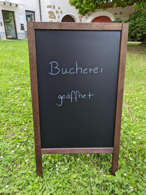 Foto eines Aufstellers mit dem Schriftzug "Bücherei geöffnet"