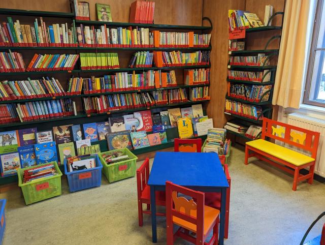 Foto vom kleinen Raum der Bücherei mit Kinderbüchern und -möbeln.